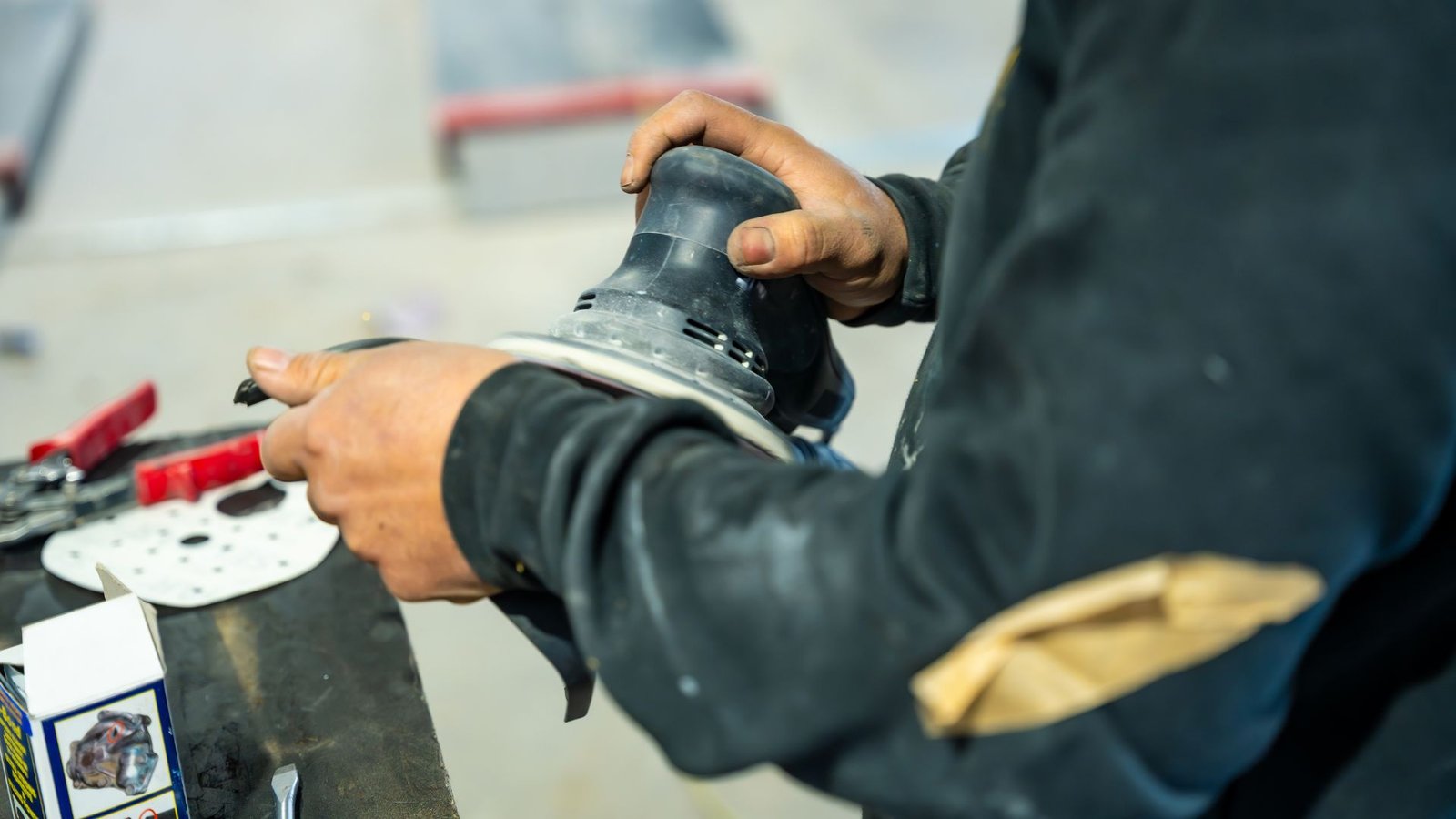 Truck panel being sanded and masked during surface preparation